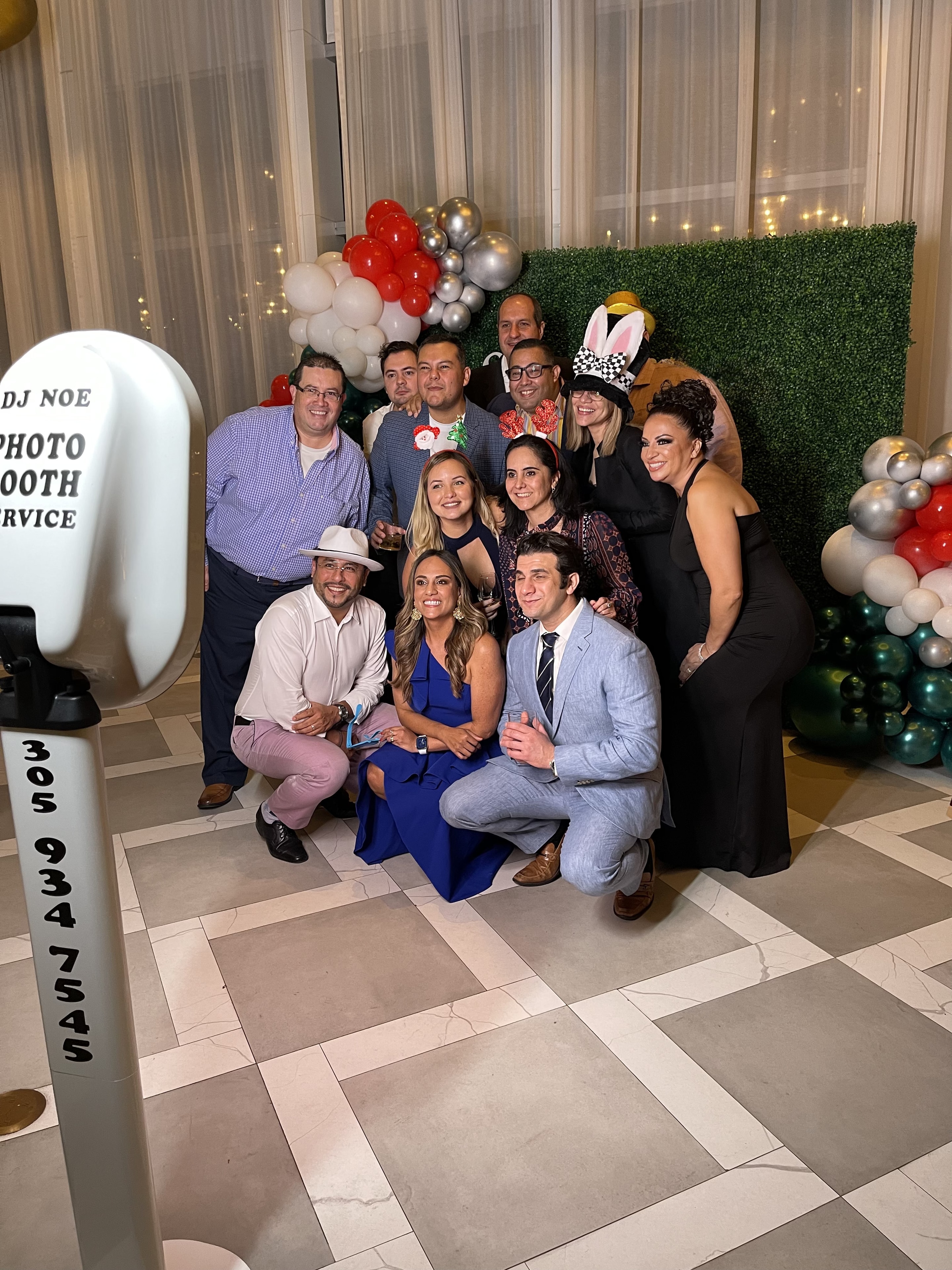 Group of guests posing with fun photo booth props at a DJ NOE Parties event